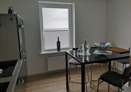 een eetkamer met een glazen tafel en een raam bij Black Pearl in Schönberger Strand