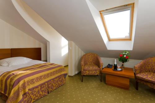 錫比烏的住宿－帕拉佐賓館，一间卧室配有一张床、两把椅子和一个窗户