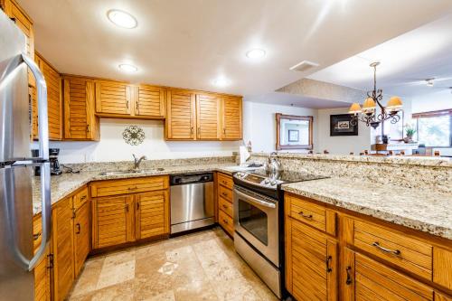 a kitchen with wooden cabinets and stainless steel appliances at Silver King by All Seasons Resort Lodging in Park City