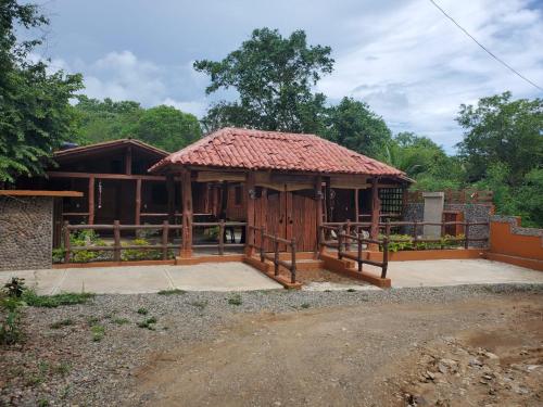 ein Holzhaus mit einem Kacheldach in der Unterkunft Cabañas Corazón in Troncones