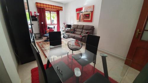 uma sala de estar com uma mesa de vidro e um sofá em Apartamento Tavira em Tavira