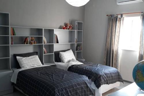 - une chambre avec un lit et une étagère dans l'établissement Ramzam - Spacious & Modern 3 bedroom apartment with roof terrace, à Marsaskala