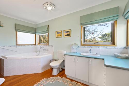 uma casa de banho com uma banheira, um WC e um lavatório. em Leighton Bay Walk em Metung