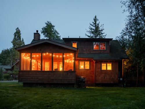 a house with christmas lights in the yard at On the River Wooded Bliss Cabin near Loloma in McKenzie Bridge