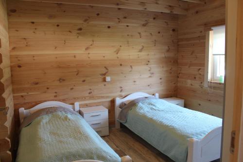 two beds in a room with wooden walls at Ferienhaus Harmonie in Twist