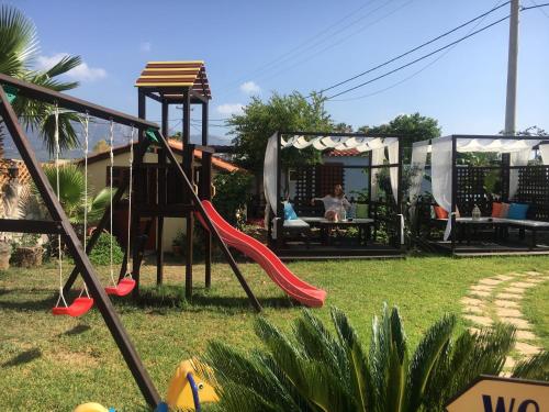 a playground with a slide in a yard at Socrates Studios in Tigaki