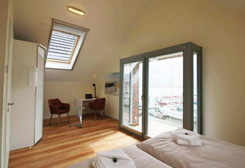 a bedroom with a bed and a desk and a window at Ostsee - Ferienhaus Nr 29a "Erste Reihe" im Strand Resort in Heiligenhafen