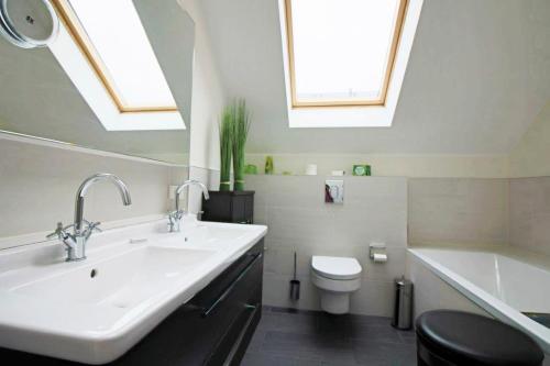 een badkamer met een wastafel, een toilet en dakramen bij Ostsee - Ferienhaus Nr 29a "Erste Reihe" im Strand Resort in Heiligenhafen
