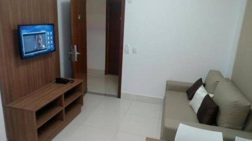 een woonkamer met een bank en een tv bij Resort Caldas Novas - Encontro das Águas in Caldas Novas