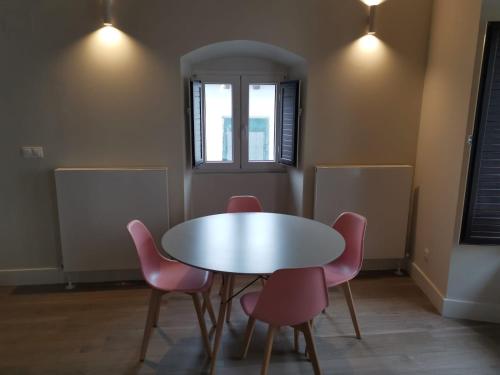 a table and four pink chairs in a room at La Rua 25 in Castro-Urdiales