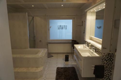 a bathroom with a tub and a sink and a bath tub at Carpe Diem IV 1324 in Landkirchen