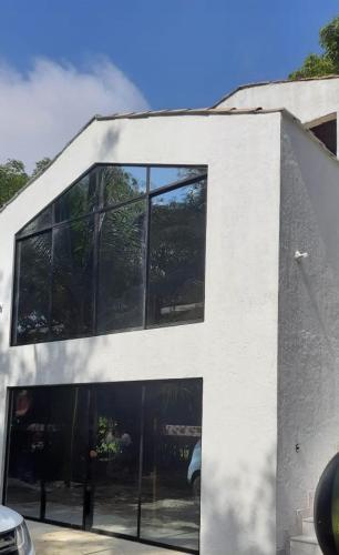 a building with glass windows on the side of it at Cabañas El Olimpo in Necoclí