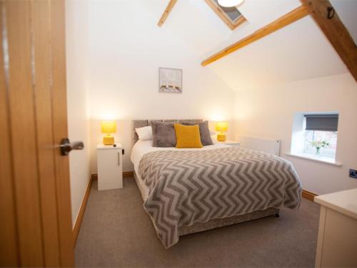 a bedroom with a bed and a window at Deerholme Cottage in Malton