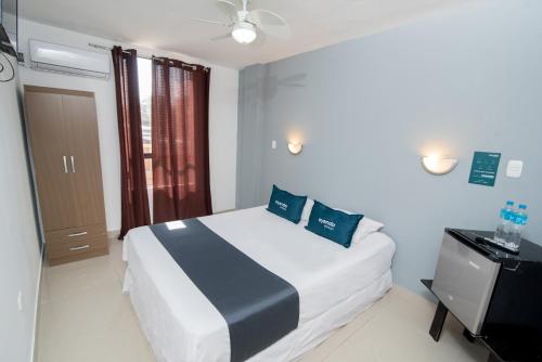 a bedroom with a white bed and a window at Ayenda Apart La Hacienda in Piura