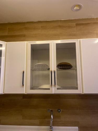 a kitchen cabinet with two glass doors over a sink at شاليه دانة بحر in Yanbu