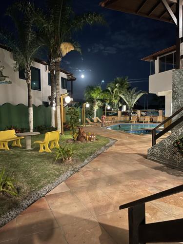 a resort yard with a pool at night at MUTA PRAIA HOTEL in Porto Seguro