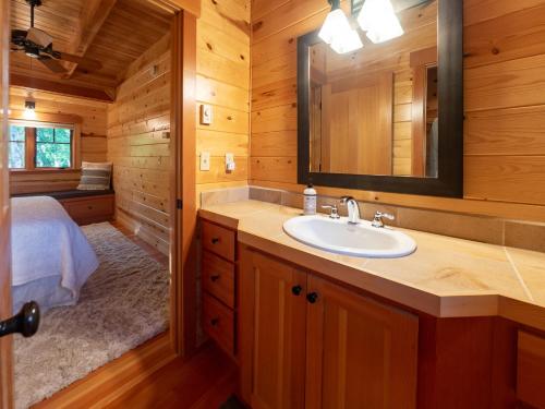 a bathroom with a sink in a log cabin at On the River Wooded Bliss Cabin near Loloma in McKenzie Bridge