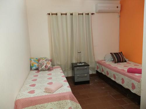 ein Schlafzimmer mit 2 Betten und einer Kommode darin in der Unterkunft Departamento 3A in Puerto Iguazú