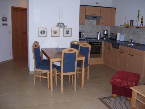 a kitchen with a wooden table and chairs at Reiseoase Kavelweg 10, Whg 2 in Zingst