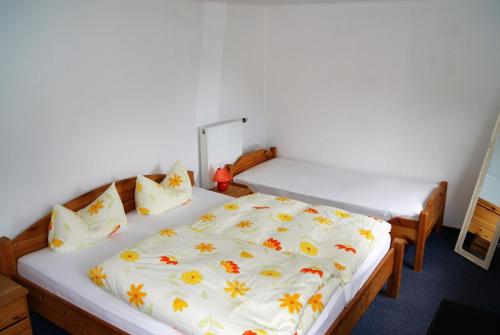 ブラウンラーゲにあるFerienwohnung Nitzschkeのベッドルーム1室(花の白いベッドカバー付)