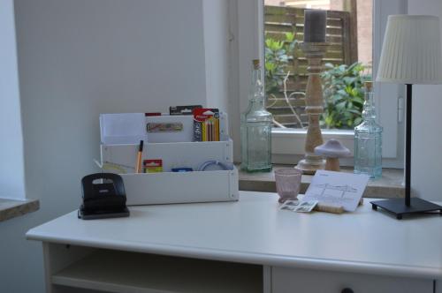 a white desk with a lamp and books on it at "Villa am NOK" in Rendsburg
