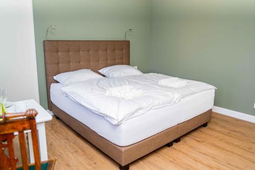 een bed met witte lakens en kussens in een slaapkamer bij Gästehaus "Alte Bücherei" Satrup in Mittelangeln