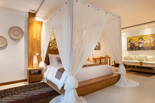 a bedroom with a bed with mosquito netting at Vije Boutique Resort & Spa in Ubud