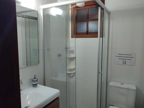 a bathroom with a shower and a toilet and a sink at Casa ,piscina há 100 metros do mar ,24 pessoas in Capão da Canoa