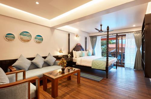 a living room with a bed and a couch at Sea Queen Beach Resort & Spa in Colva