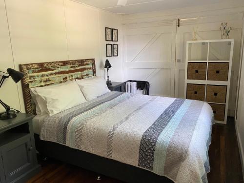 a bedroom with a bed with a striped comforter at Boatsheds in Sawtell