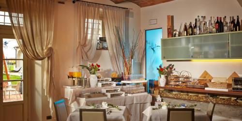 a dining room with tables with white tablecloths at Locanda Sant'Agata in San Giuliano Terme