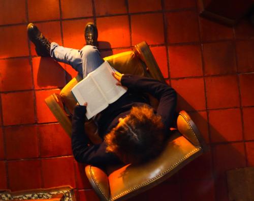 a man laying in a chair reading a book at Libélula Cabaña- Alojamiento rural in Duitama