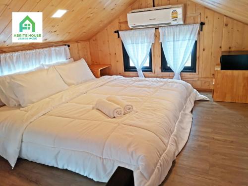 a bedroom with a large white bed with towels on it at Tiny house on Koh Lanta only 2 mins walk to the beach in Ban Mo Nae