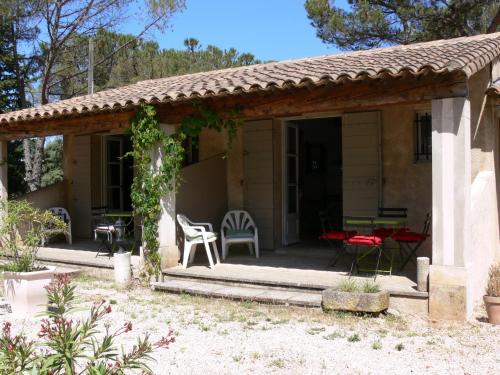 a cottage with a patio and a table and chairs at La Coudoulière in Saint-Rémy-de-Provence