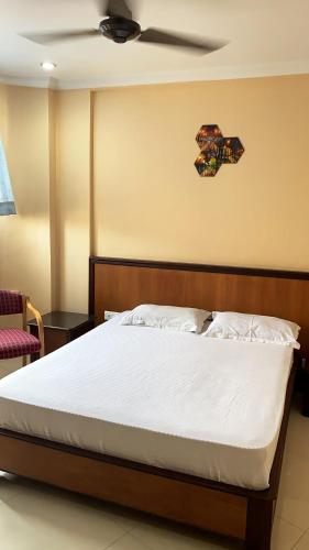 a bedroom with a bed with a ceiling fan at Hotel Meridian Palace in Kannur