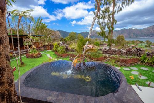 una piscina con una fuente en un jardín en Break Villa Kintamani by ecommerceloka en Kintamani