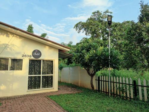 a house with a fence and a tree in the yard at JenJon Karjat Resort - One BHK Premium Chalet with optional SWIMMING POOL in Karjat