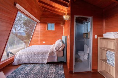 um quarto com uma cama e um WC num quarto em Refugio de Guacheneque, Glamping y Hospedaje Rural em Villapinzón