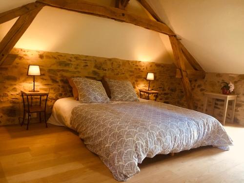 um quarto com uma cama king-size e paredes de pedra em Jolie maison en Périgord Vert em Nantheuil