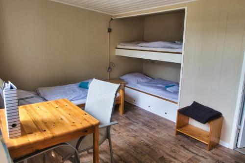 een kamer met 2 bedden, een tafel en een bureau bij Finnenhaus 8 in Lübeck