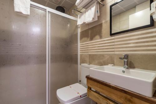 Un baño con inodoro, lavabo y ducha. en laden hotel bodrum, en Bodrum City