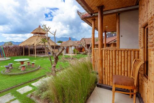 a building with a chair and a yard with a playground at Batur Bamboo Cabin by ecommerceloka in Kintamani