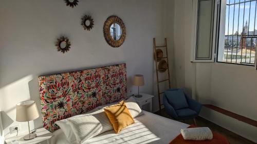 - une chambre avec un lit et une chaise bleue dans l'établissement Casa Mora Triana, à Séville