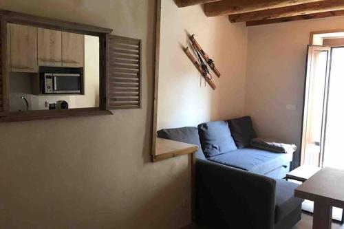 a living room with a blue couch and a mirror at Puigcerdá Centro. Acogedor apartament en el pueblo in Puigcerdà