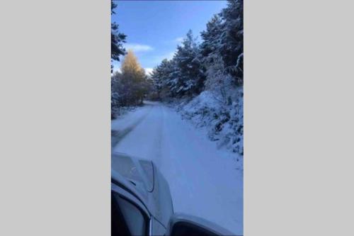 a car is driving down a snow covered road at Puigcerdá Centro. Acogedor apartament en el pueblo in Puigcerdà