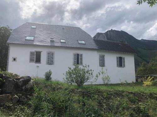 a white house with a mountain in the background at L 'Air d'Aspe in Accous