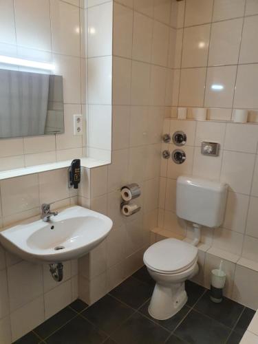 a bathroom with a white toilet and a sink at Pension Seibel in Munich