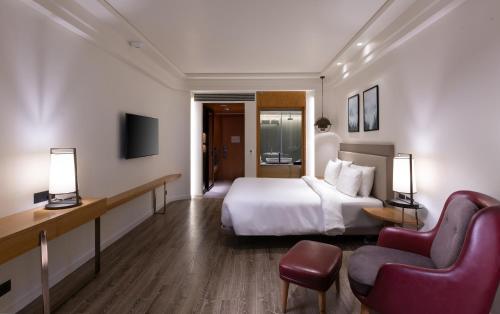 a hotel room with a bed and a chair at The Oasis Mussoorie - A Member of Radisson Individuals in Mussoorie