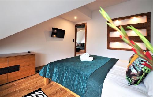a bedroom with a bed and a dresser at VIP Apartamenty Stara Polana in Zakopane