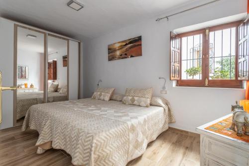 a bedroom with a bed and two windows at Casa Loli in Frigiliana